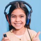 Child wearing headphones and holding button during hearing test.