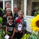 Image shows a teacher and schoolchildren alongside sunflowers.