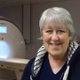 Image shows a woman standing in front of an MRI scanner