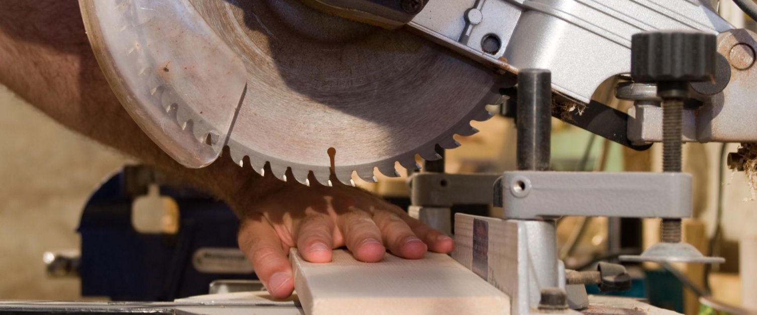 Image shows close up of fingers by circular saw blade