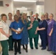 Image shows a group of people standing in a hospital ward