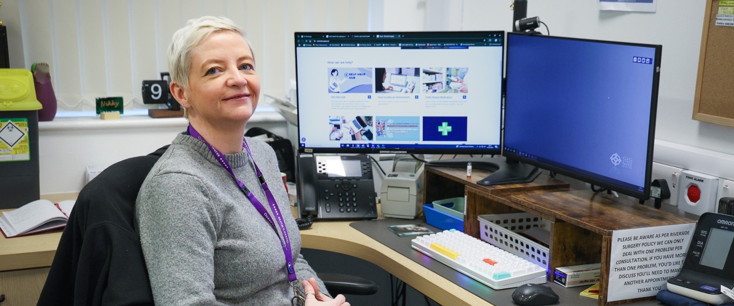 Nicola sat at a desk with a computer