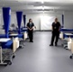 Image shows staff in scrubs stood between beds in an empty and unused ward.