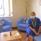 Picture shows a midwife sitting on a blue sofa in hospital quiet room.