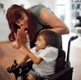 Child in a wheelchair high fiving an adult. Both are smiling.