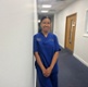 Image shows a woman standing in a corridor