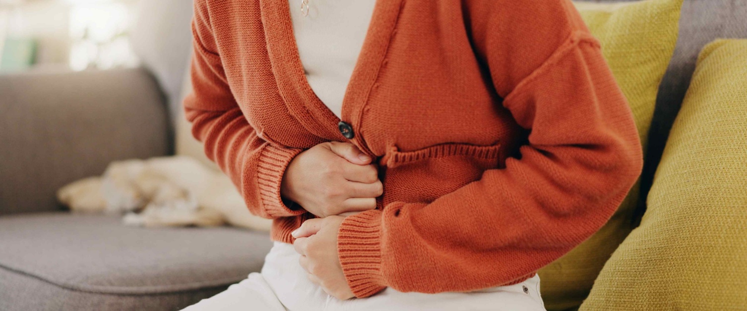 A woman clutching her stomach in pain
