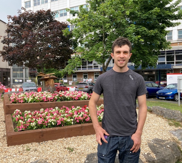 A man standing next to a flower bed
