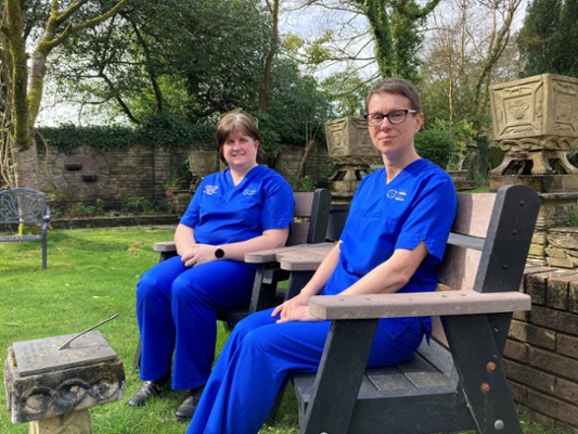 Image shows two women sitting on a bench