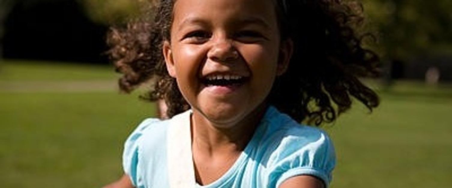 A happy young girl running in a field