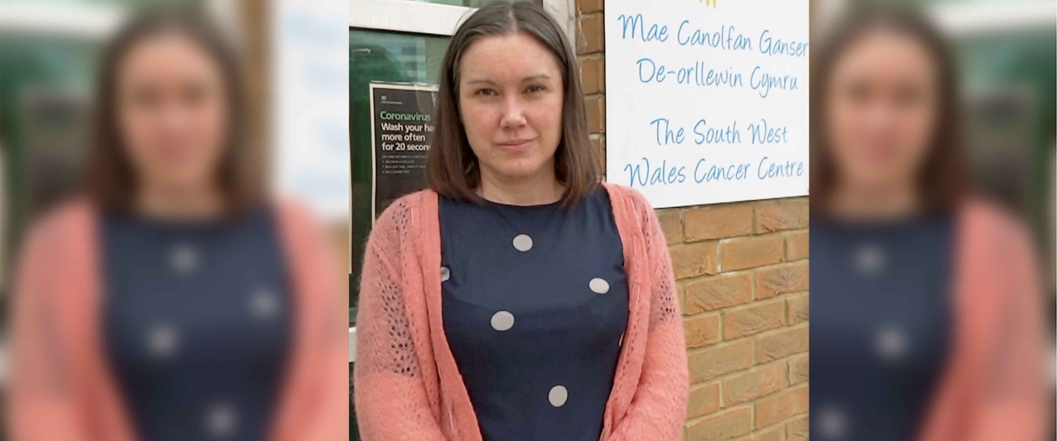 Image shows a staff member outside a hospital building