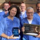 Image shows cardiac staff in scrubs, holding the award
