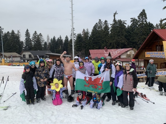 Image shows a group of people standing in snow