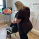 A patient sitting on a chair is having her hair styled.