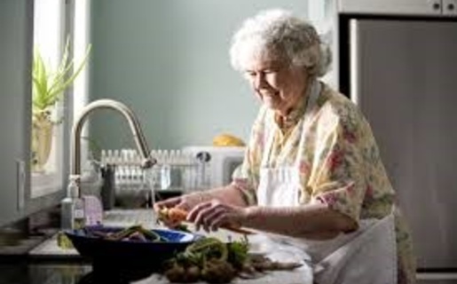 An image of an elderly woman doing the washing up