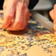Hands working on a jigsaw puzzle.