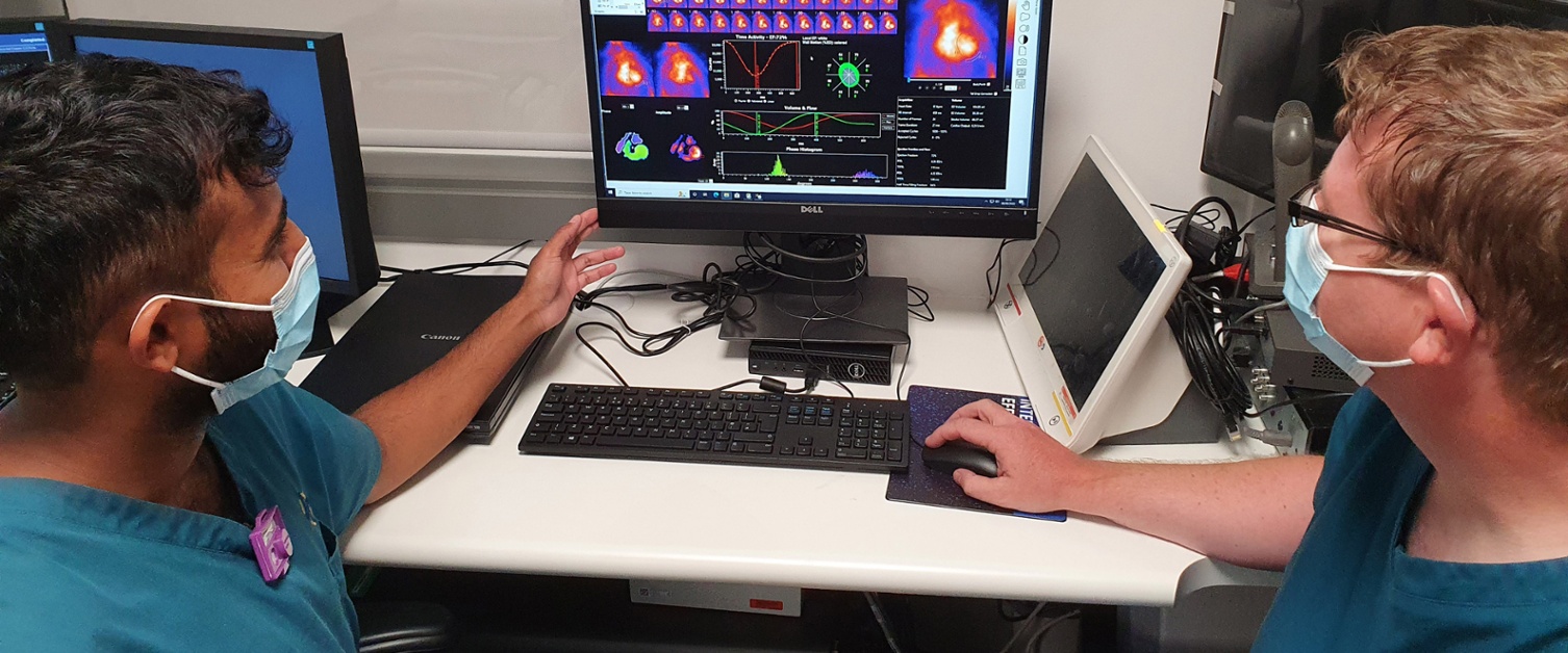 Image shows two hospital staff viewing a computer monitor