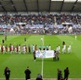 Footballers on a pitch with a big banner in front of them reading 