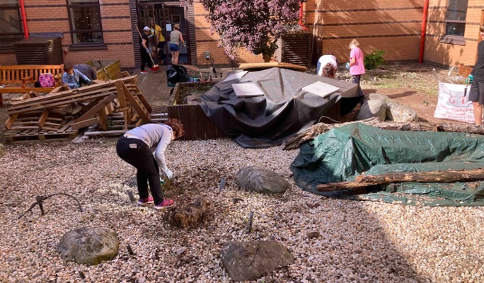 Image shows people clearing a courtyard