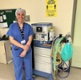 Image shows a woman standing in front of a machine