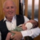 Image shows a smiling couple holding a baby.
