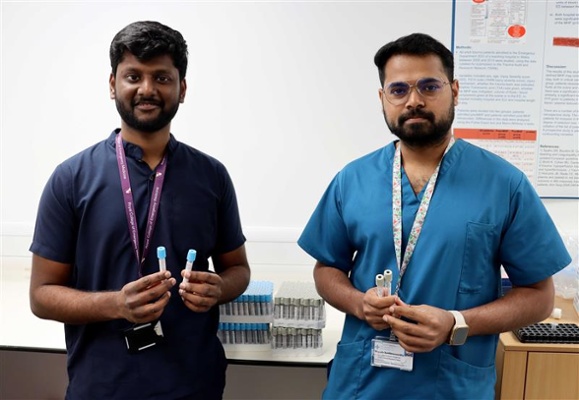 Image shows two men holding bottles