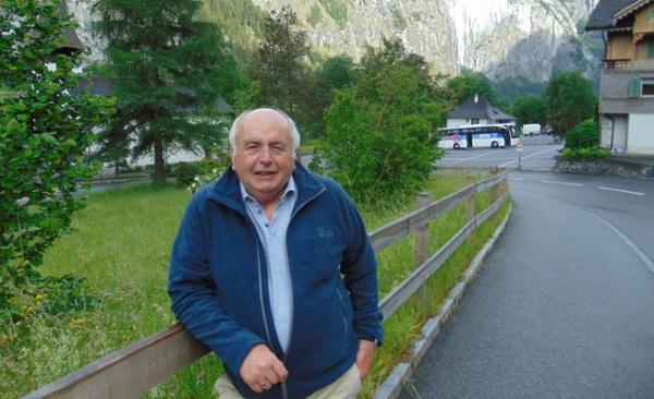 Image shows a man with mountains in the background.