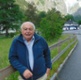 Image shows a man with mountains in the background.