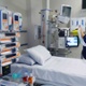 Image shows a nurse standing alongside an intensive care bed.