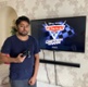 Image shows a man standing in front of a television