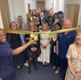Image shows a group of people stood behind a ribbon