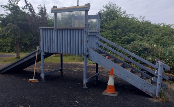 A delapidated wooden slide in a playground