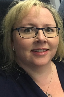 A headshot of a woman wearing glasses