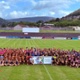 Image shows a large group of women rugby players on a pitch.