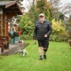 A man wearing a medical device on his leg is pictured walking a dog