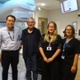 Image shows four people in a radiotherapy room.