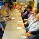 Image shows people seated around a cafe table.