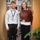 Two smiling members of staff surrounded by books in a library