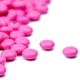 Image shows bright pink amitriptyline tablets on white background.