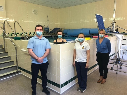 Image shows people standing around a hydrotherapy pool