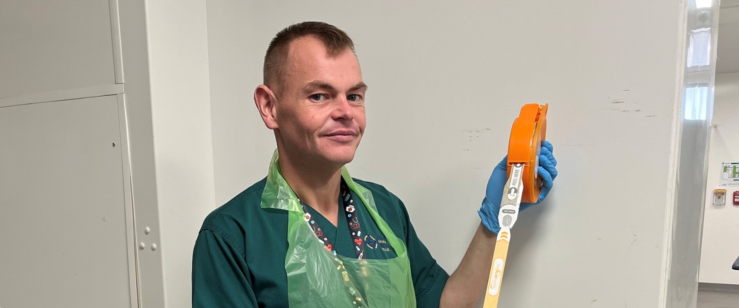 Image shows a man holding a medical device
