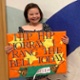 Isabella holds a sign saying Hip Hip Hooray I Rang The Bell Today.
