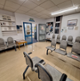 Image shows 4 rows of grey chairs in a large room with posters on the wall. There are double glass doors in the corner of the room leading to the outpatient department.