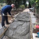 A Ford volunteer lays the concrete for a new accessibility ramp
