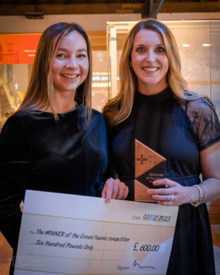 Image shows two women holding a cheque