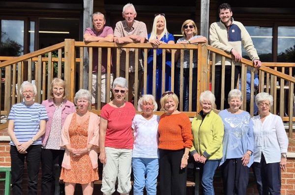 Image shows a group of people outside a pavillion.