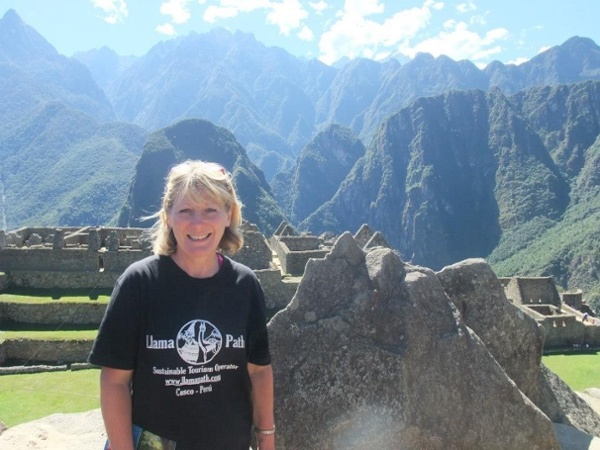 A woman standing with mountains in the background