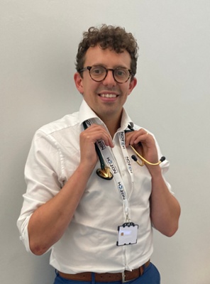 Image shows a man holding a stethoscope