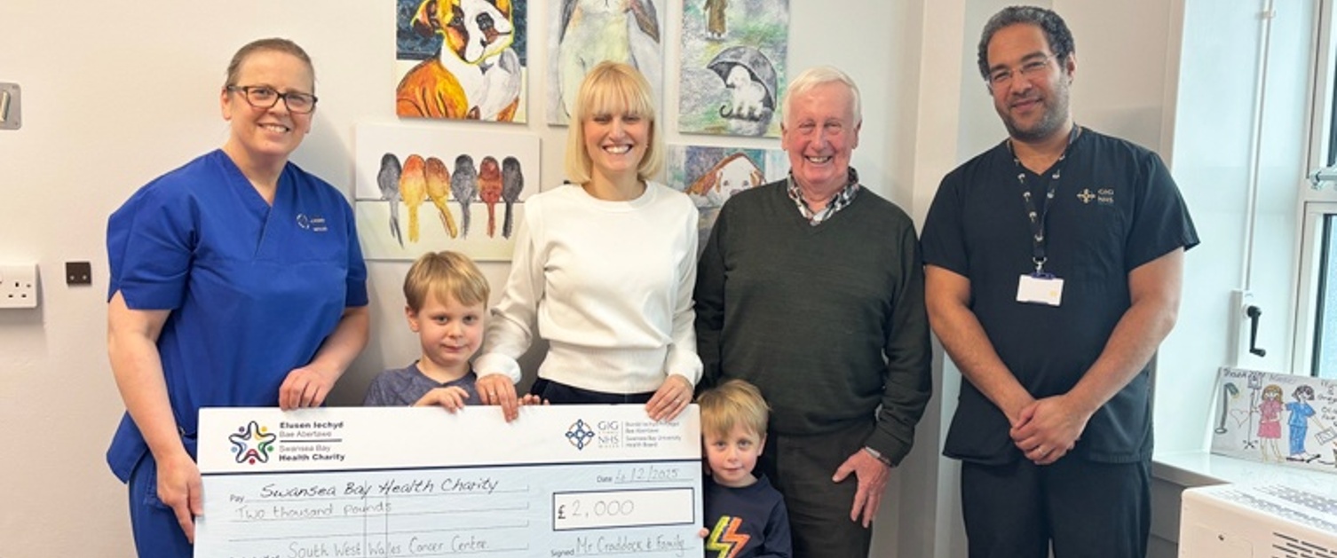 Image shows a group of people holding a large cheque.