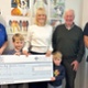 Image shows a group of people holding a large cheque.